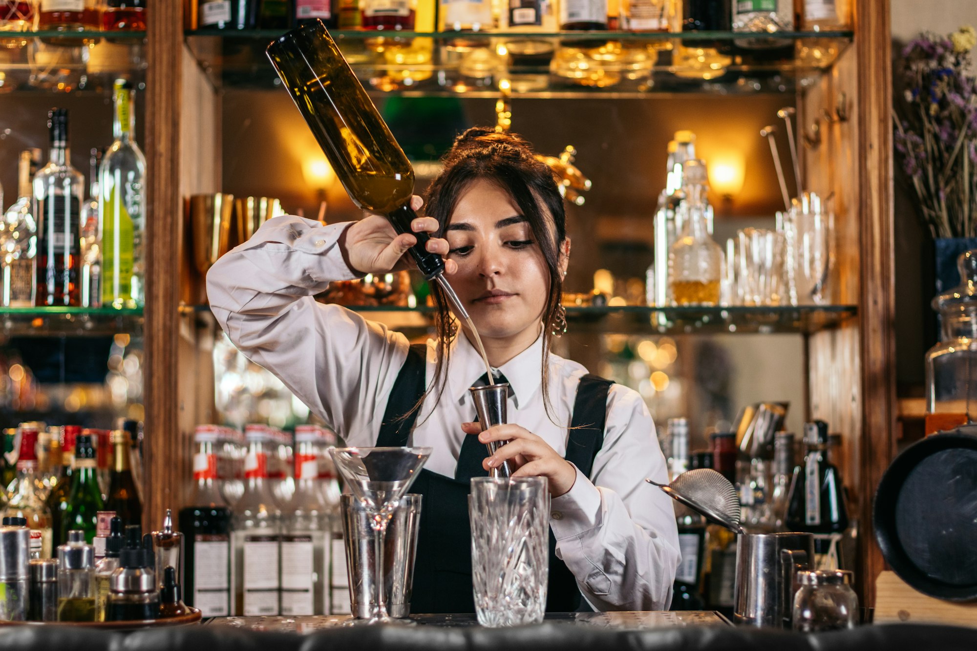 Female bartender preparing a cocktail in a traditional cocktail bar