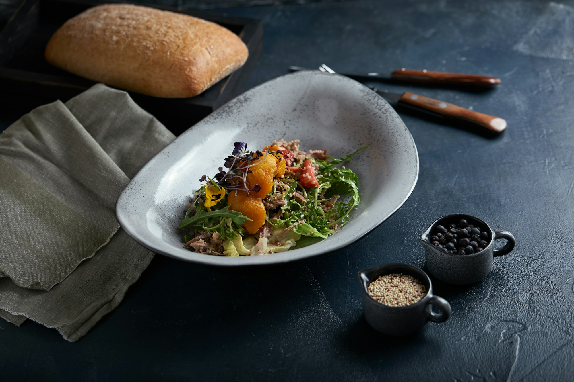 Salad with duck strawberries and mango on a dark background, low key. Food photo concept. Restaurant